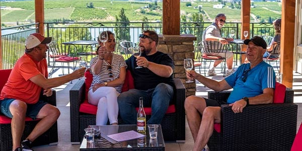 Four people enjoying wine on a patio