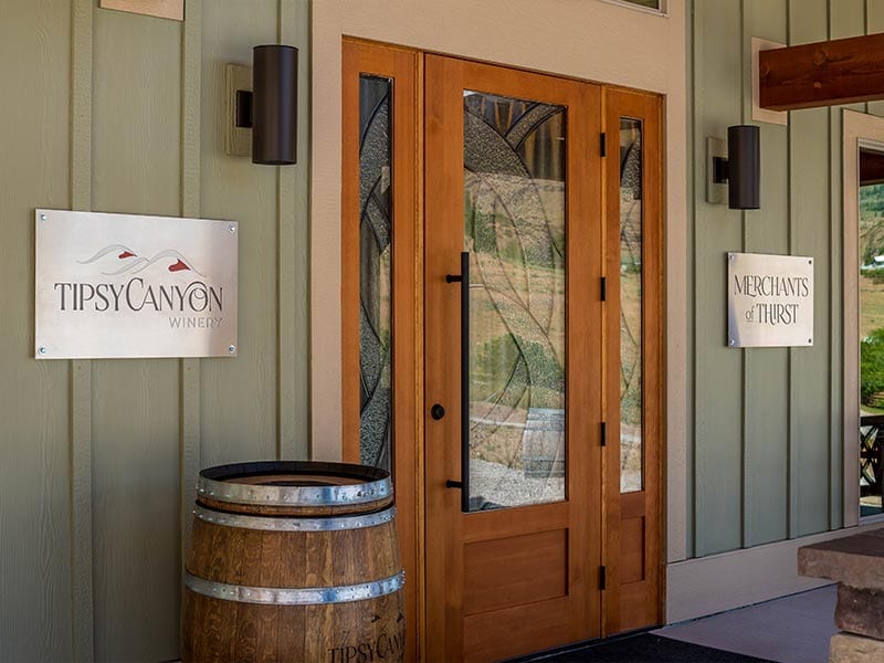 Front door of Tipsy Canyon Winery. Sign to the right of the door says "Merchants of Thirst"