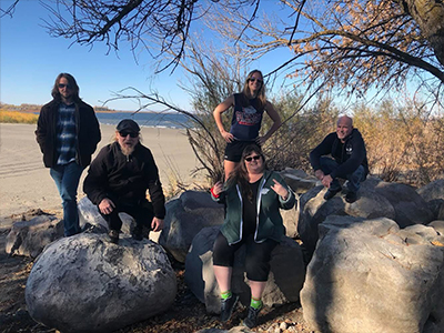 Five members from the band The Spin-offs sitting on rocks